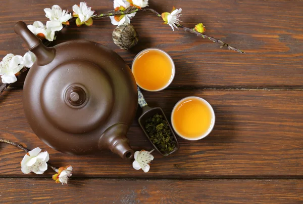 Tea set (teapot, cups and different green tea) a wooden background, top view — Stock Photo, Image