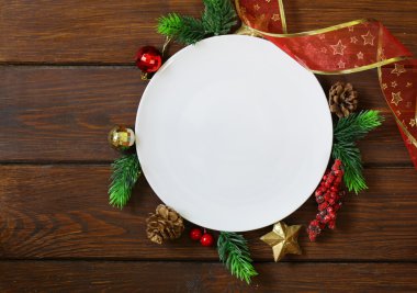 Noel çam dalları, dekorasyon ve beyaz tabak ahşap arka plan