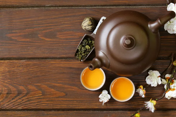 Thee (theepot, bekers en verschillende groene thee) een houten achtergrond instellen, bovenaanzicht — Stockfoto