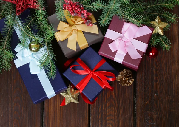 Cajas de regalo con cintas festivas y decoraciones navideñas sobre fondo de madera —  Fotos de Stock