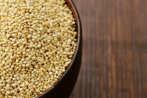 Quinoa de cereal orgânico natural em uma mesa de madeira — Fotografia de Stock