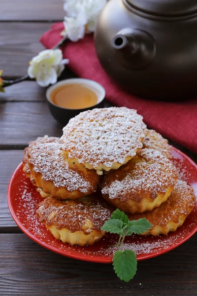 Mini madeleine muffins met poedersuiker op een rode plaat — Stockfoto