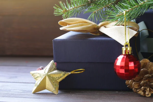 Cajas de regalo con cintas festivas y decoraciones navideñas sobre fondo de madera — Foto de Stock