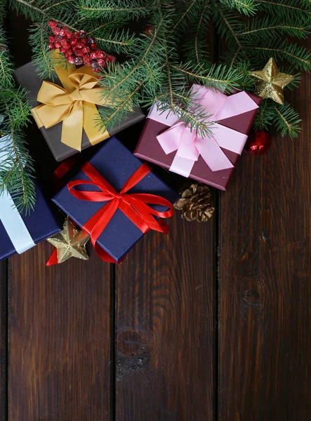 Cajas de regalo con cintas festivas y decoraciones navideñas sobre fondo de madera — Foto de Stock