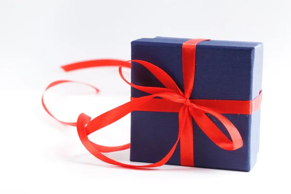 Geschenkdoos met rood lint op een witte achtergrond — Stockfoto