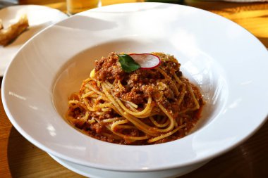 Restoranda beyaz tabakta spagetti bolonez.