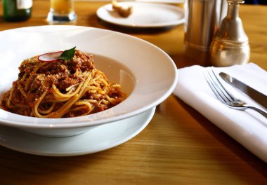 Restoranda beyaz tabakta spagetti bolonez.