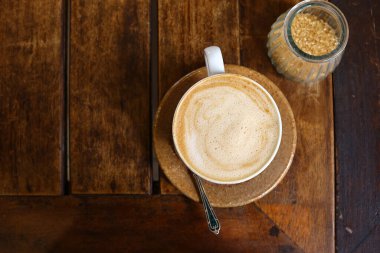 Kahve molası için ahşap masada bir fincan kapuçino.