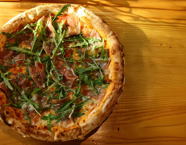 Jambonlu pizza, taze roka ve parmesan peyniri.