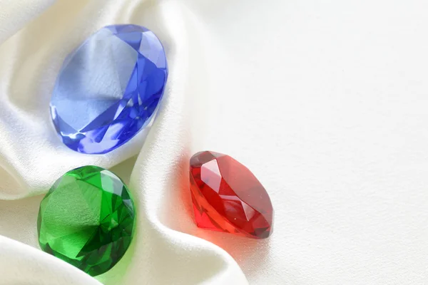 Színes üveg a gyémántok a puha selyem háttér — Stock Fotó