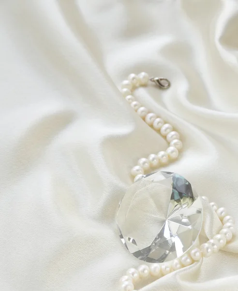 Grand diamant de verre et collier de perles sur un fond de soie douce — Photo