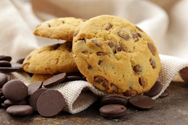 Biscoitos saborosos doces com chips de chocolate na mesa — Fotografia de Stock