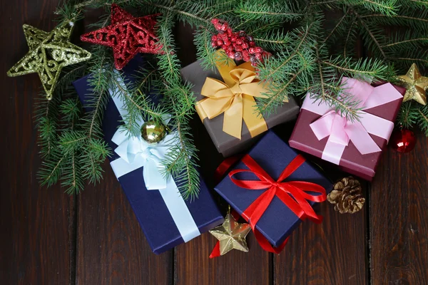 Scatole regalo con nastri festivi e decorazioni natalizie su sfondo di legno — Foto Stock