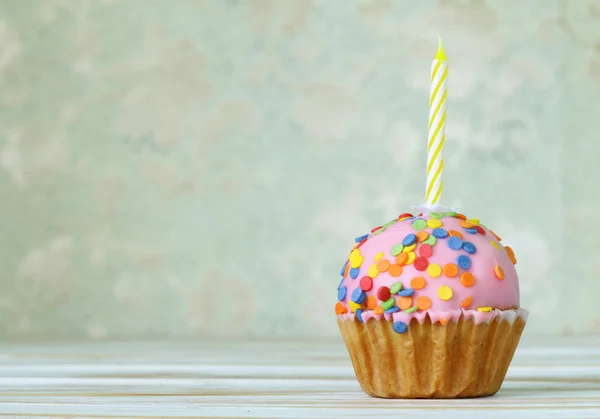 Cupcakes festivos com uma vela em um fundo vintage — Fotografia de Stock