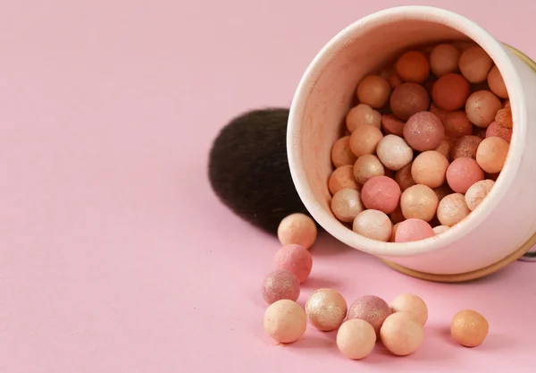 Kosmetika rouge bollar i banken på en rosa bakgrund — Stockfoto