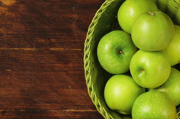 Manzanas verdes orgánicas frescas en una canasta sobre un fondo de madera —  Fotos de Stock