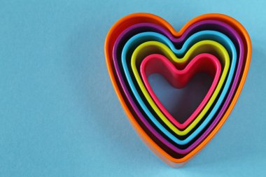 mavi bir arka plan üzerinde renkli plastik Kalpler