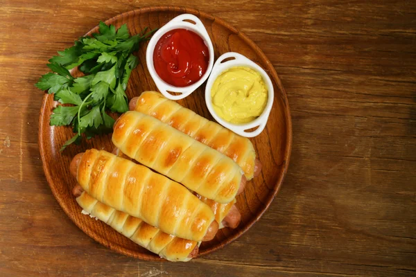 Salchicha horneada en masa con ketchup y mostaza —  Fotos de Stock