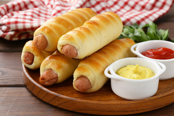 sausage baked in dough with ketchup and mustard
