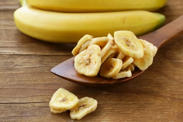Banana chips, dried fruit on a wooden table — Stock Photo, Image