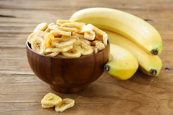 Banana chips, dried fruit on a wooden table — Stock Photo, Image