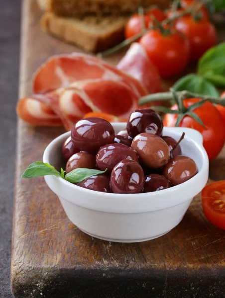 Natura morta del cibo italiano olive, pomodori, basilico, prosciutto — Foto Stock
