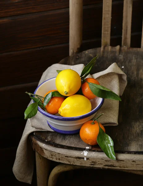 Mandarinas y limones cítricos en la vieja silla vintage —  Fotos de Stock