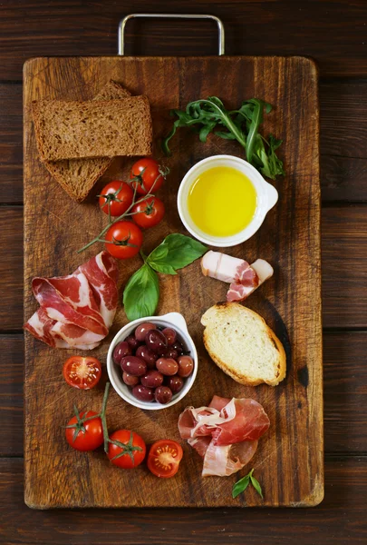 Итальянская кухня натюрморт - оливки, помидоры, базилик, ветчина прошутто — стоковое фото