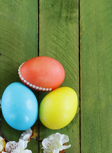 Pasen symbool kleurrijke beschilderde eieren op een houten achtergrond — Stockfoto