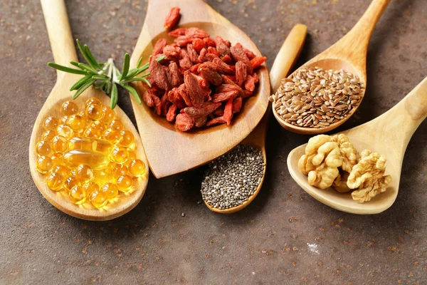 Super alimentos - bayas de goji, semillas de chía, semillas de lino, nueces y cápsulas omega-3 — Foto de Stock