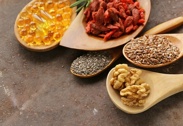 Super jídlo - goji bobule, chia semena, lněná semena, vlašské ořechy a omega-3 kapsle — Stock fotografie