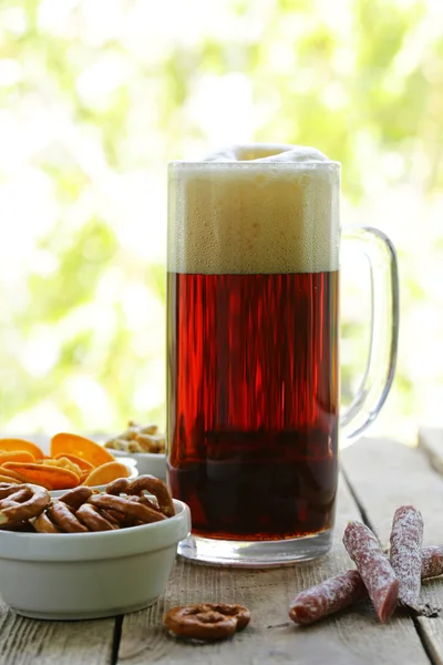 Diferentes lanches salgados e um copo de cerveja fresca, vida tranquila rústica — Fotografia de Stock