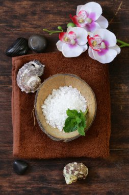 Spa konsept - havlu, tuz ve ahşap arka plan üzerinde orkide