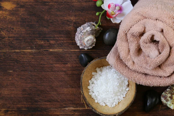 Spa concept - towel, salt and orchid on wooden background — Stock Photo, Image