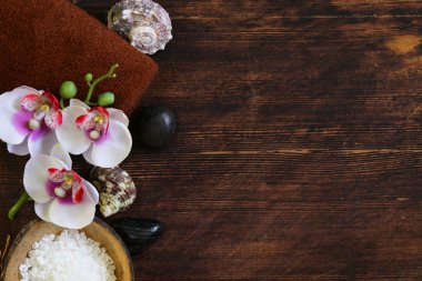 Spa konsept - havlu, tuz ve ahşap arka plan üzerinde orkide