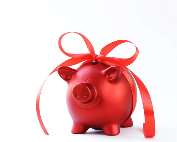 Red piggy bank with gift ribbon on white background — Stock Photo, Image