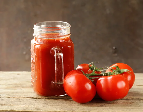 Fresh tomato juice in a glass jar on the table — Stock Photo, Image