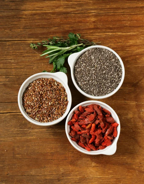 Super alimentos - bayas de goji, semillas de chía, semillas de lino, nueces y cápsulas omega-3 — Foto de Stock