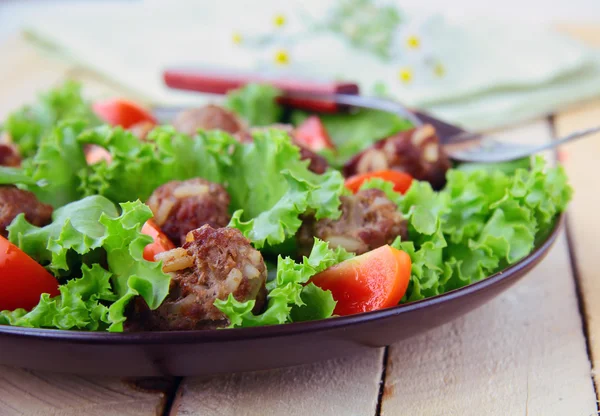 Sallad med kött bollar och grönsaker på ett träbord — Stockfoto