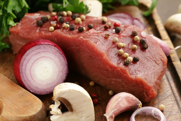 Carne fresca de res cruda en una tabla de cortar con verduras y especias —  Fotos de Stock