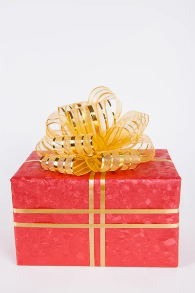 Single red gift box with gold ribbon .