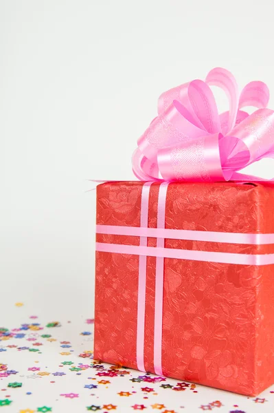 Красный подарочный коробок с розовой лентой и луком — стоковое фото