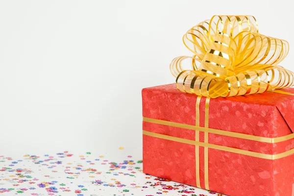 Caja de regalo roja con cinta de oro y lazo . — Foto de Stock