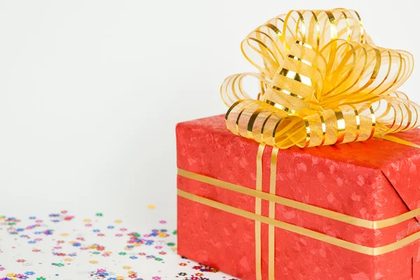 Caja de regalo roja con cinta de oro y lazo . — Foto de Stock