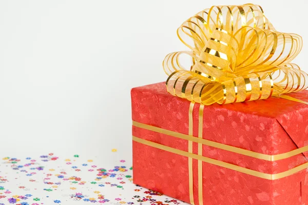Caja de regalo roja con cinta de oro y lazo . — Foto de Stock