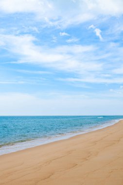 Mavi gökyüzü, dalga ve kumsal arka planının güzelliği.