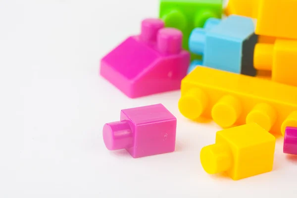 Edificio de juguetes bloques de colores sobre fondo de papel blanco — Foto de Stock