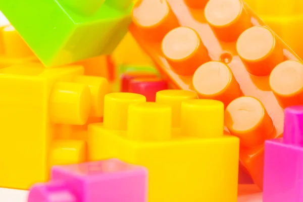 Edificio de juguetes bloques de colores sobre fondo de papel blanco — Foto de Stock