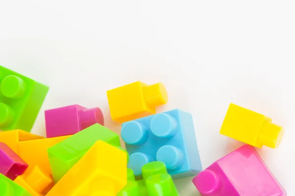 Edificio de juguetes bloques de colores sobre fondo de papel blanco — Foto de Stock