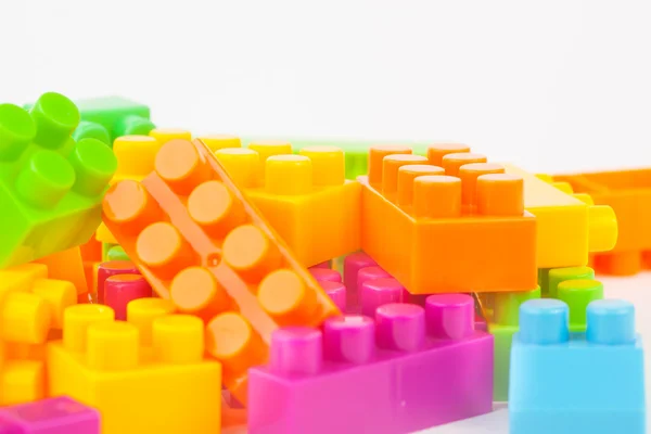Edificio de juguetes bloques de colores sobre fondo de papel blanco — Foto de Stock